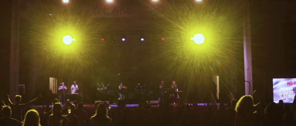 Band performing on stage for crowd.